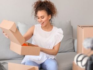 Woman happily unboxing some merch she's received in the mail